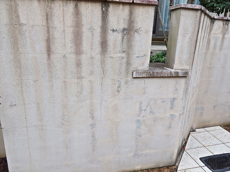 塀の汚れは上部の石の割れ目から汚れた水が集中して流れるため。溝があることは変わらないので、塗装後も徐々に汚れていきます。